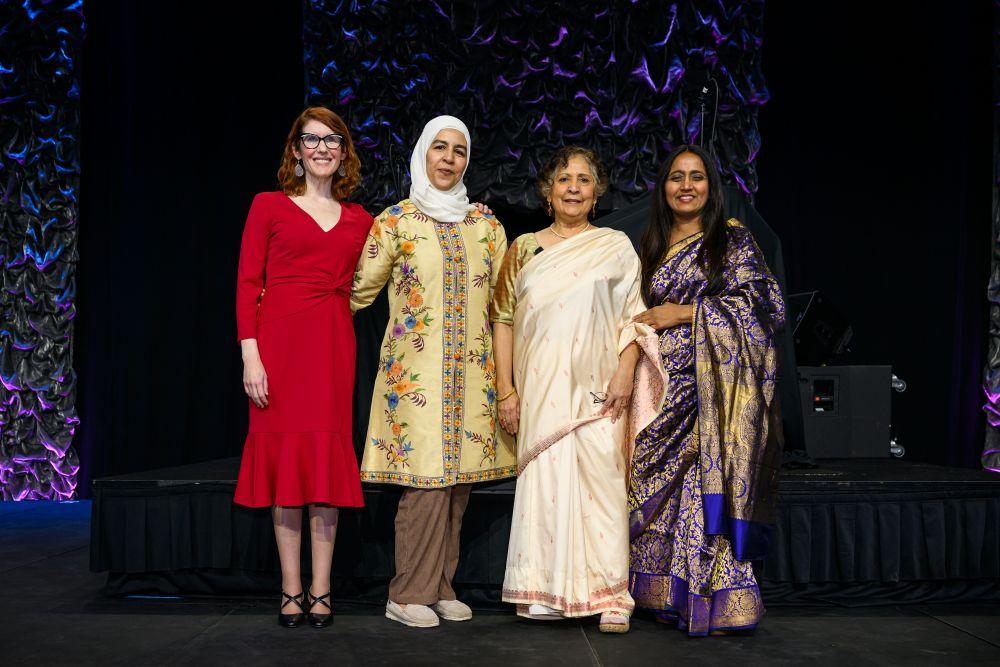 The four Montessori Voices speakers pose on stage at the event.