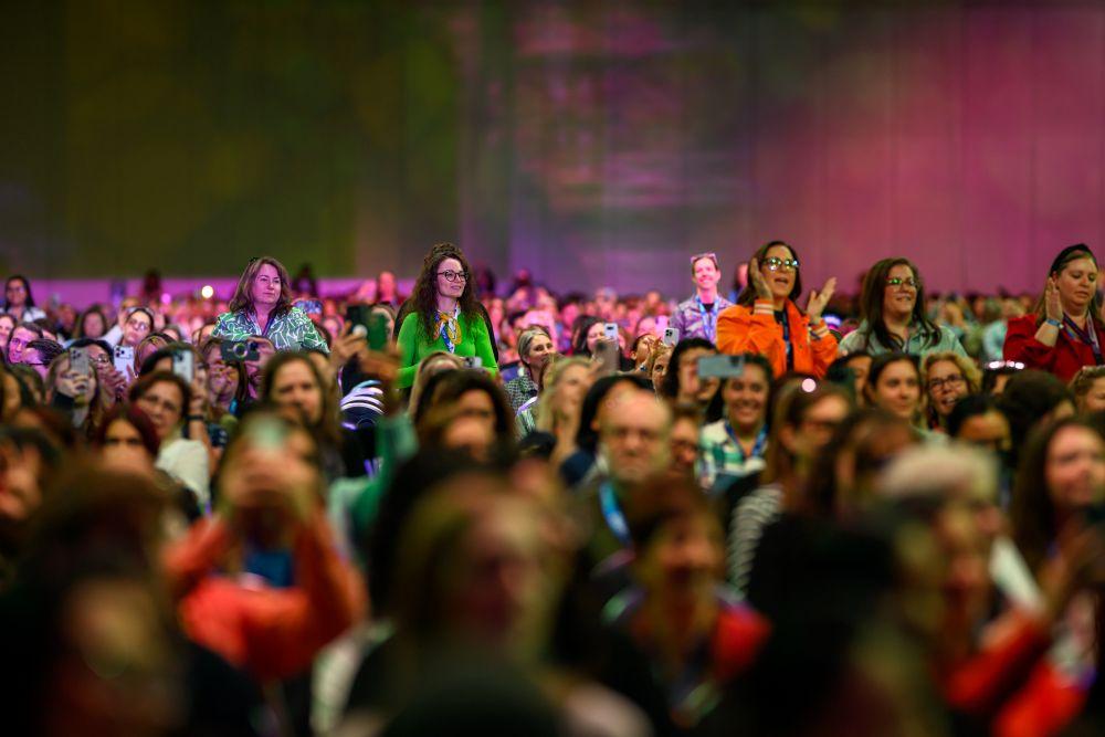 A packed house at The Montessori Event, a view of the crowd with individuals standing and clapping